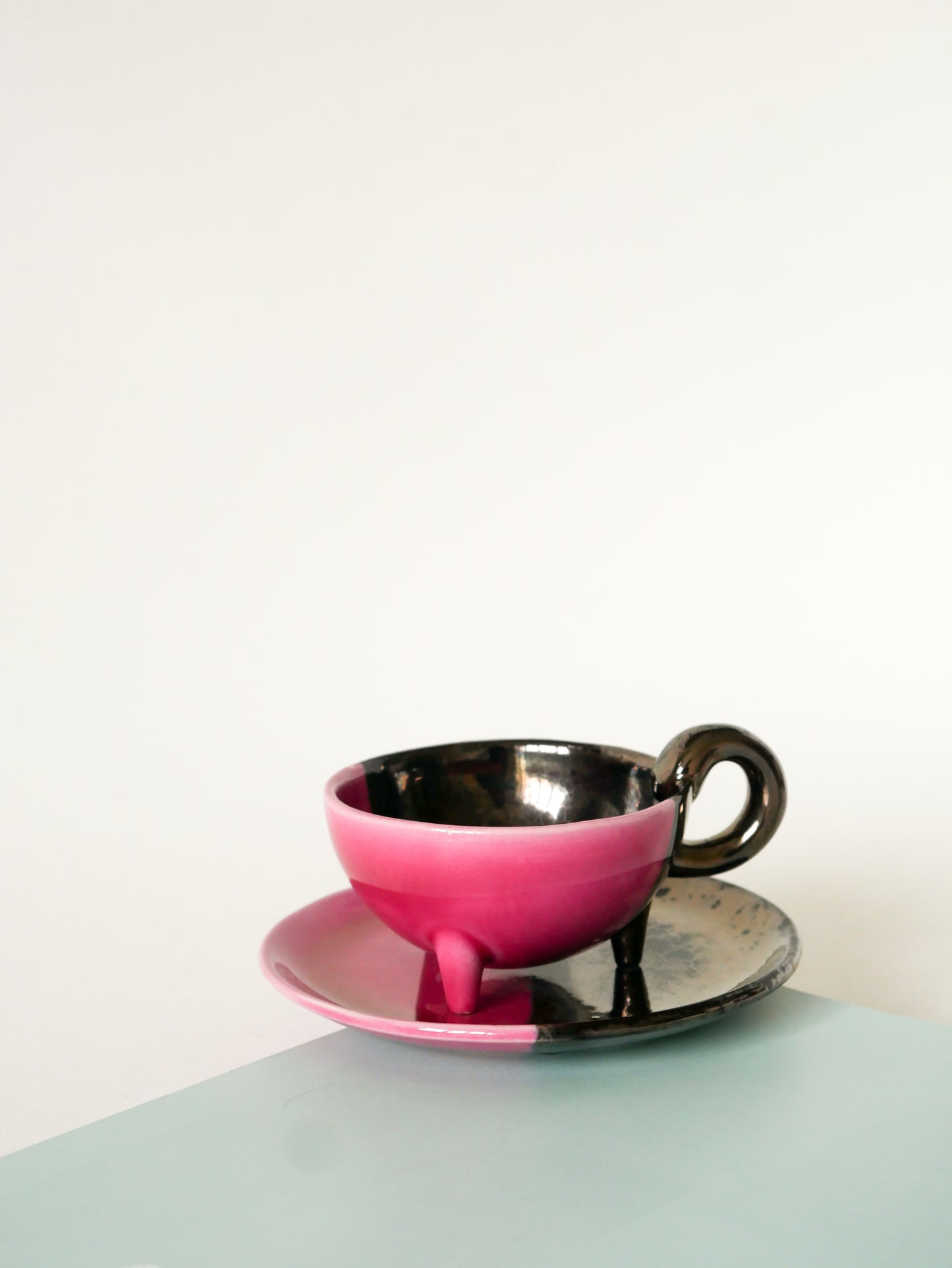 Duo de tasses tripodes et soucoupes Vallauris en céramique bicolore, Rose et Noir Irisé, 1970