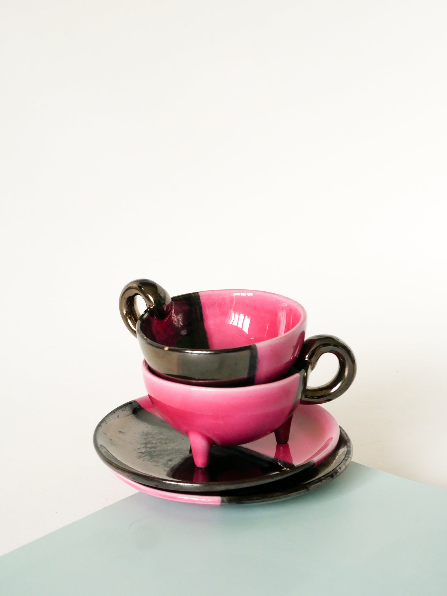 Duo de tasses tripodes et soucoupes Vallauris en céramique bicolore, Rose et Noir Irisé, 1970