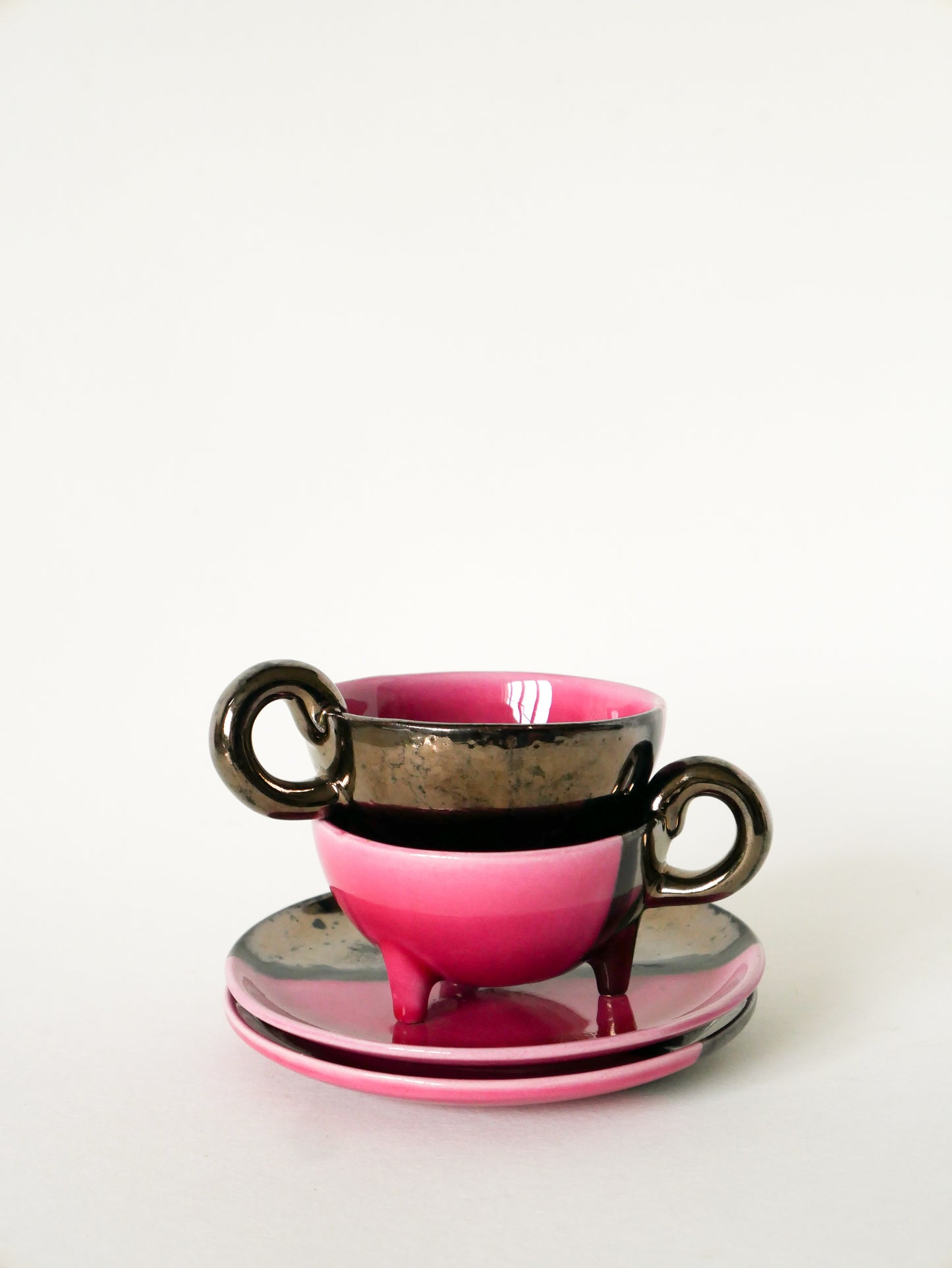 Duo de tasses tripodes et soucoupes Vallauris en céramique bicolore, Rose et Noir Irisé, 1970