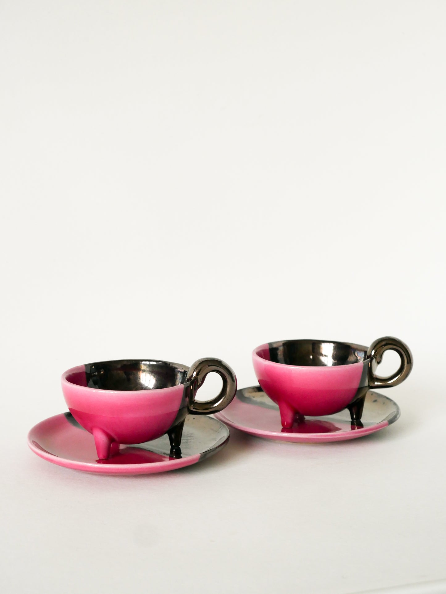 Duo de tasses tripodes et soucoupes Vallauris en céramique bicolore, Rose et Noir Irisé, 1970